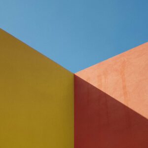 a yellow and red wall with a blue sky in the background
