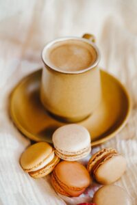 a cup of coffee and some macaroons on a plate